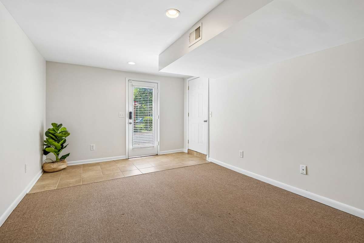 Expansive lower-level bonus room with flexible space for an office, playroom, or additional living area, plus exterior access.