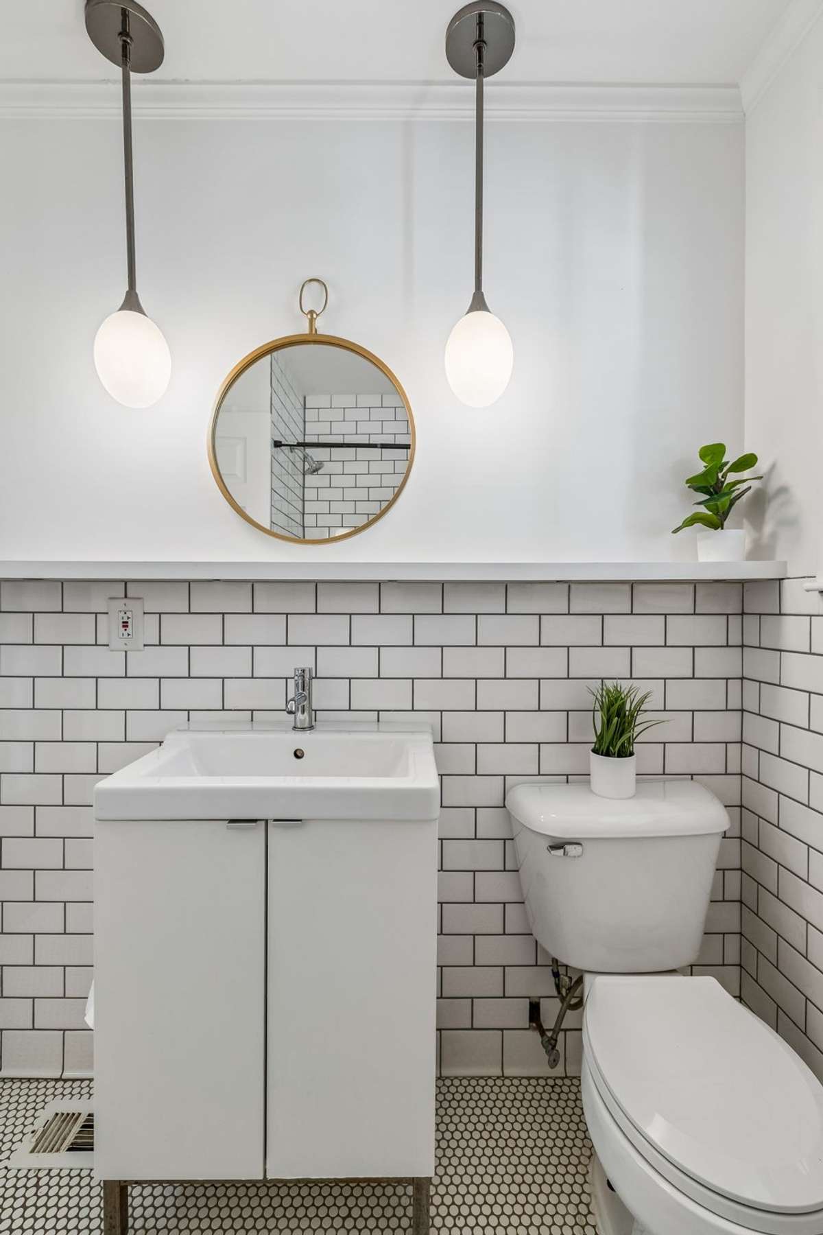 Stylishly updated main-level bathroom with classic tile, modern fixtures, and fresh, bright finishes.
