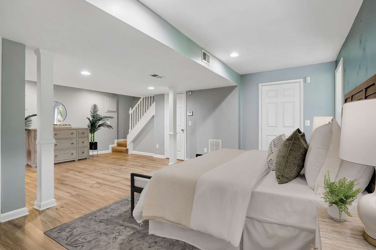 Lower-level primary suite with brand new luxury vinyl flooring and private entrance—ideal for an owner-occupied rental or guest space. (virtually staged)