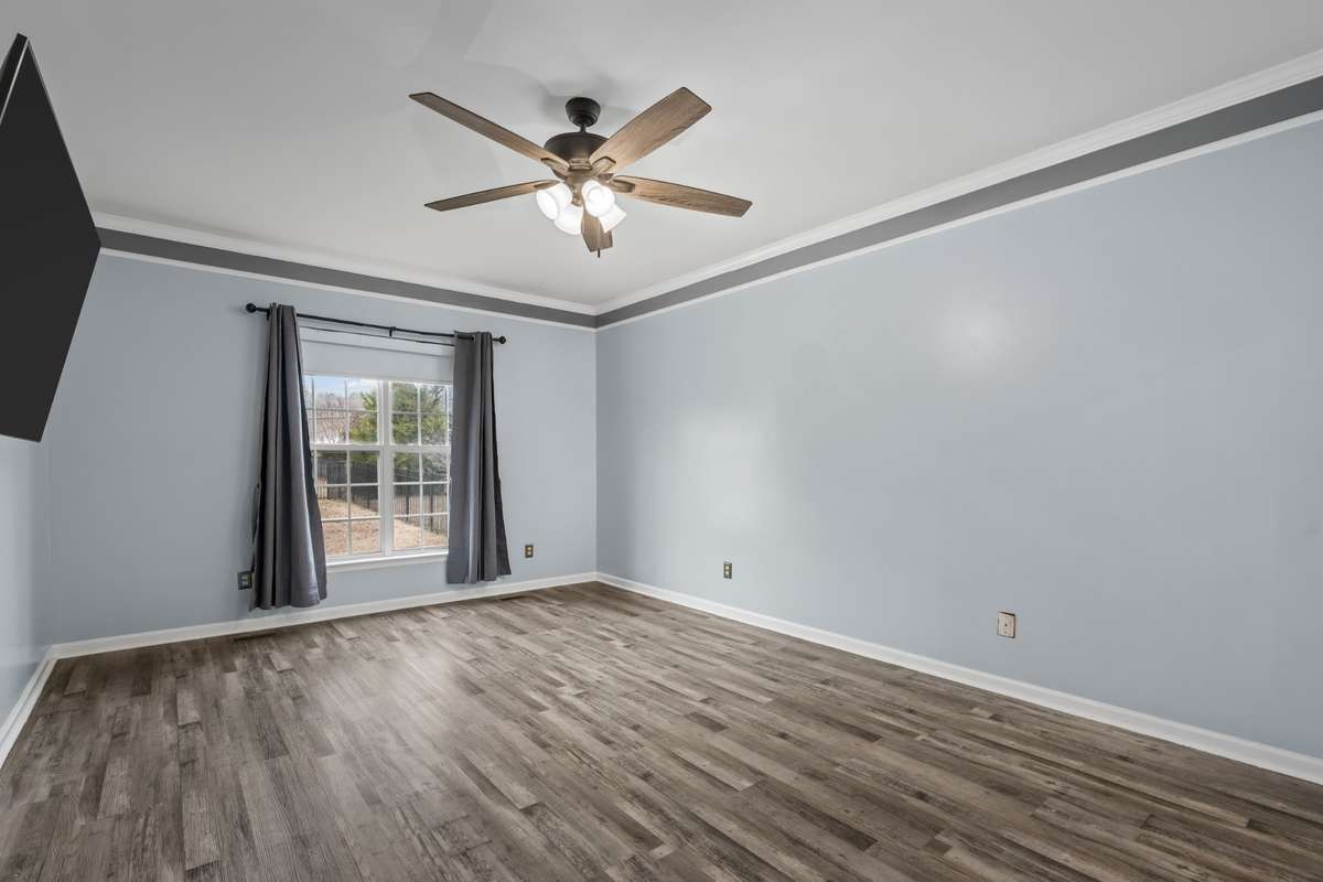 Another bedroom with wood flooring, crown molding