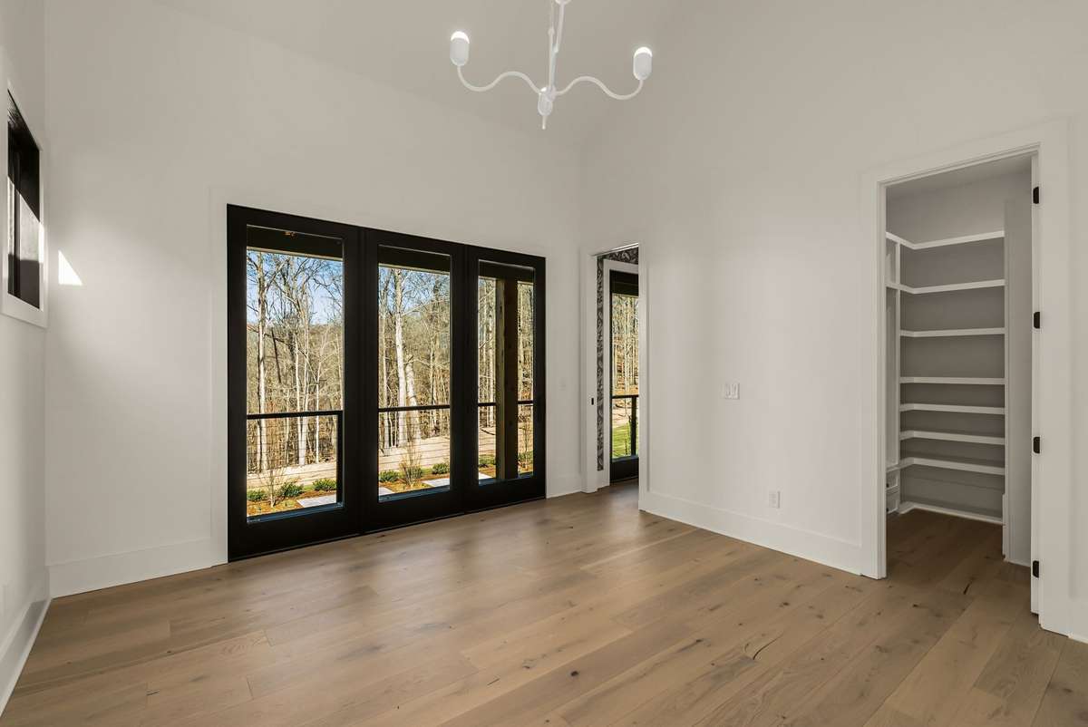 Upstairs bedroom with direct access to a private outdoor space, offering natural light and peaceful treetop views.