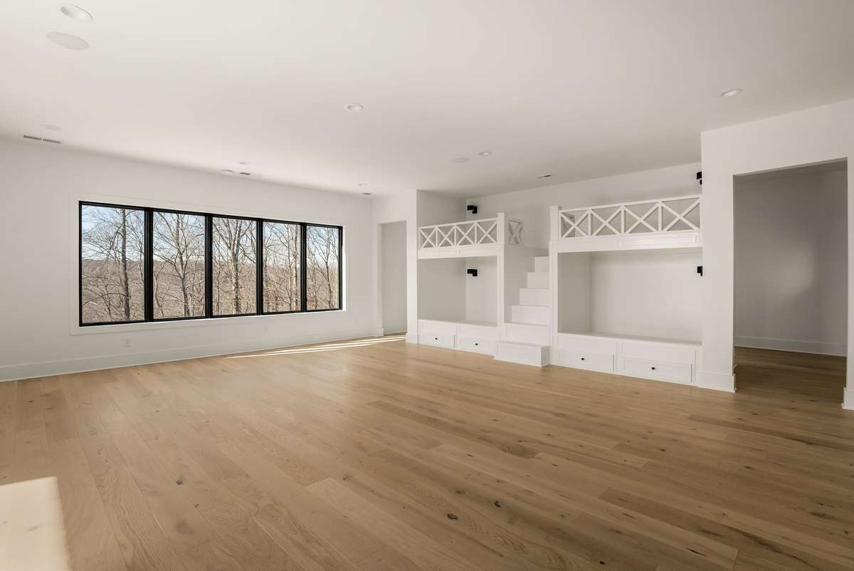 An expansive upstairs flex space with custom built ins, offering endless possibilities for a media room, creative space, or gathering area.