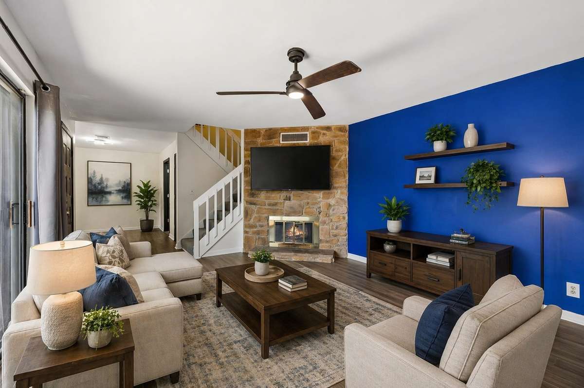 Large living room with stacked stone wood burning fireplace, & ceiling fan. 101 Cedarwood Lane, Madison, TN 37115