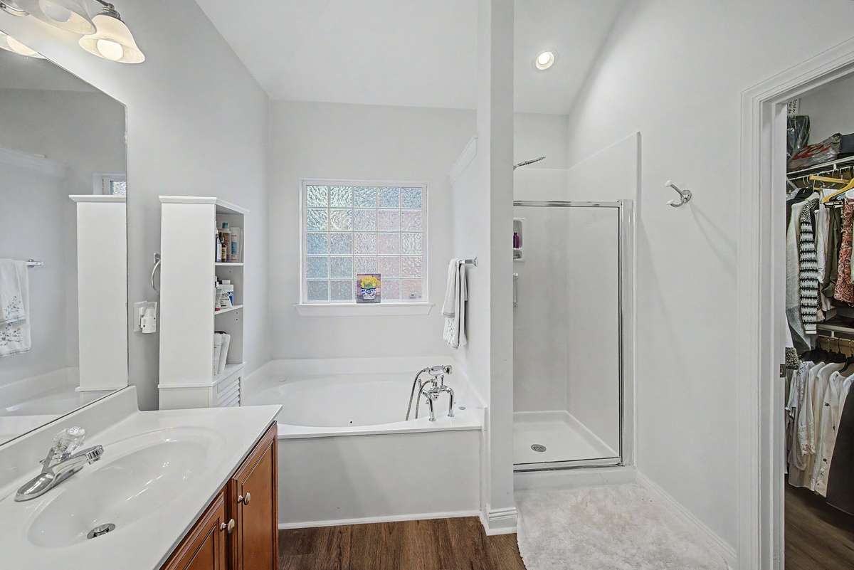 The primary bathroom features double vanities, a jetted tub & walk-in shower.