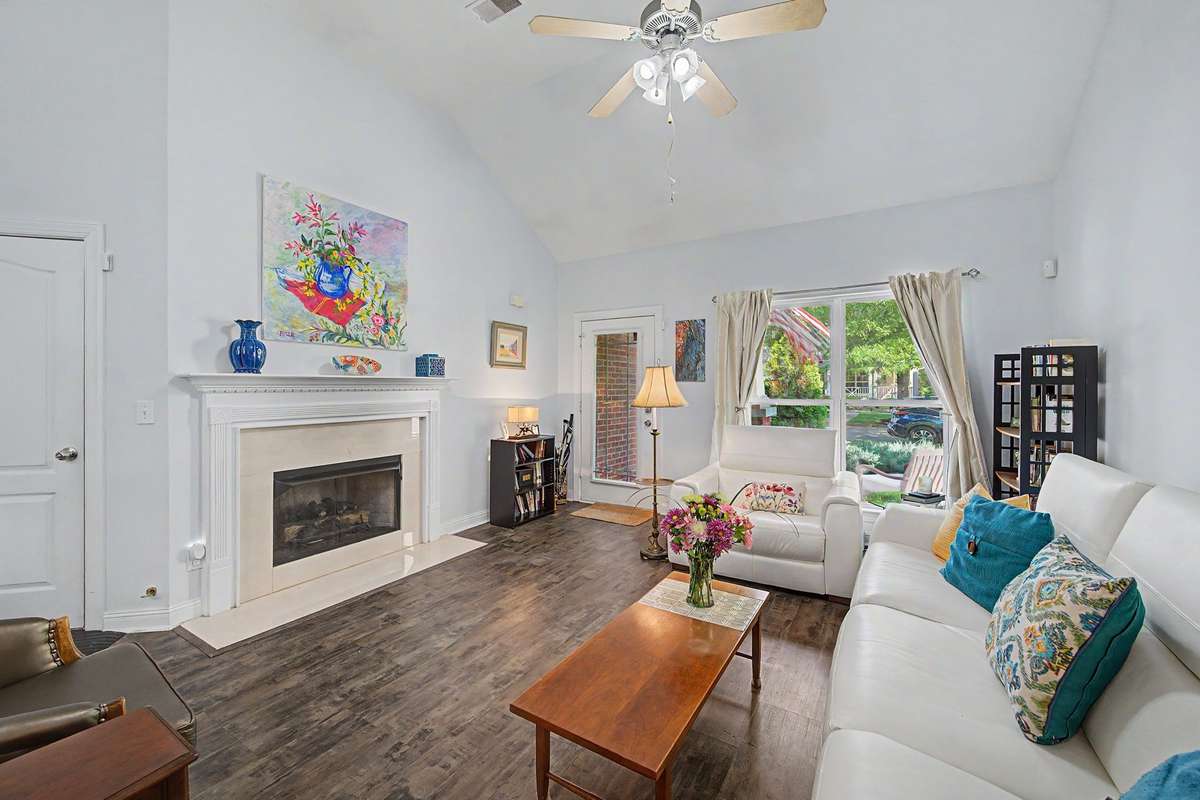 The double-height open living room has a gas fireplace and leads to the open kitchen and dining room.