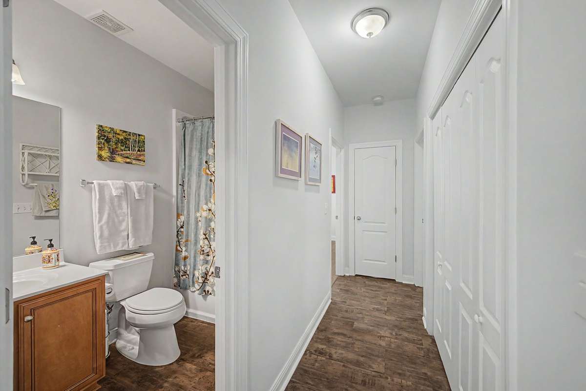 This hallway leads to two secondary bedrooms, a shared bathroom, a laundry room & utility closet.