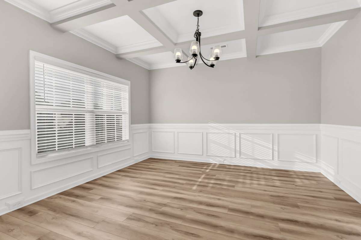 Large Formal Dining Room Features a Coffered Ceiling & Wainscoting!
