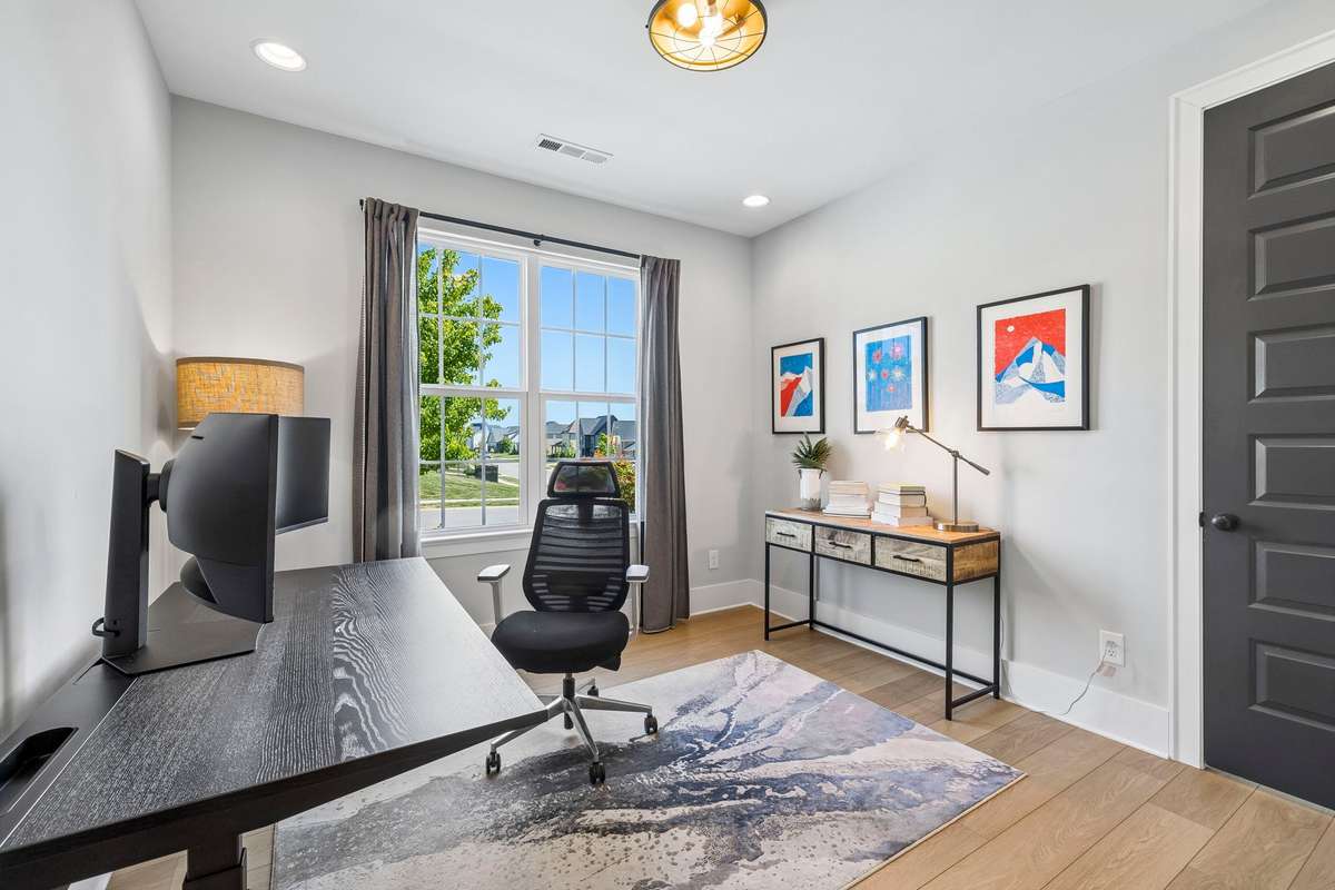 Secondary bedroom downstairs features a walk-in closet and can also serve as a great home office