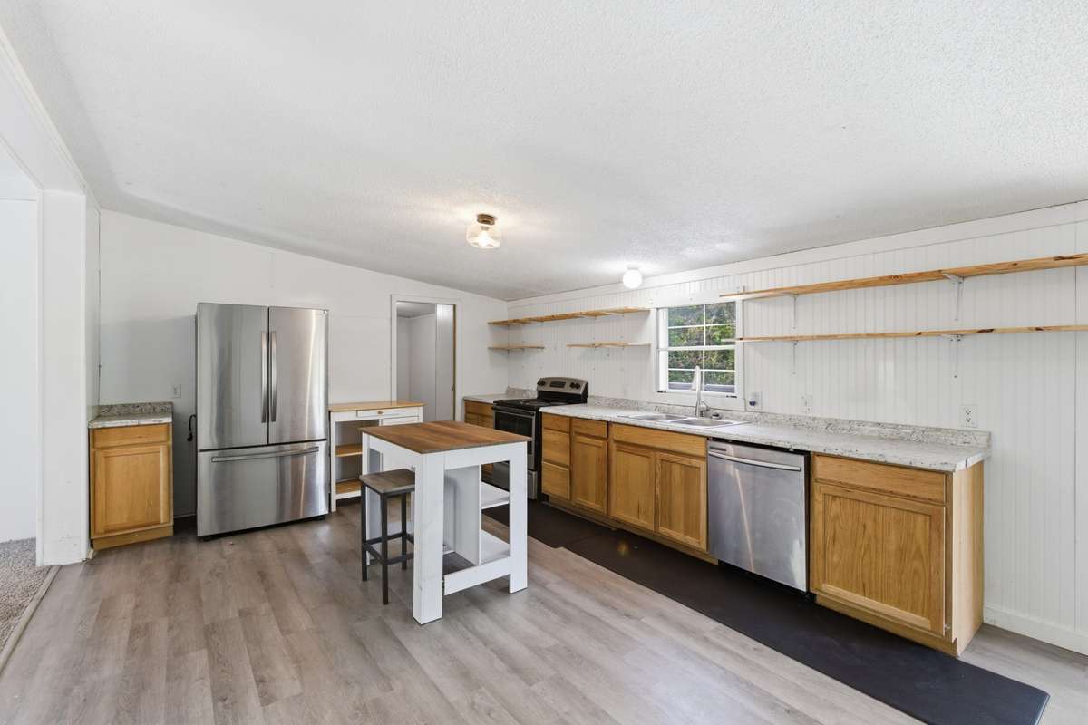 Kitchen with island and walk-in pantry. Refrigerator, dishwasher and stove/oven remain