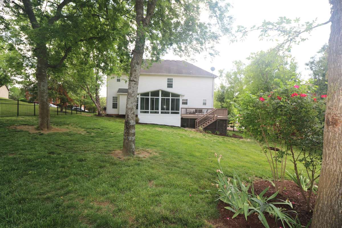 The fenced backyard has beautiful mature trees and landscaping.