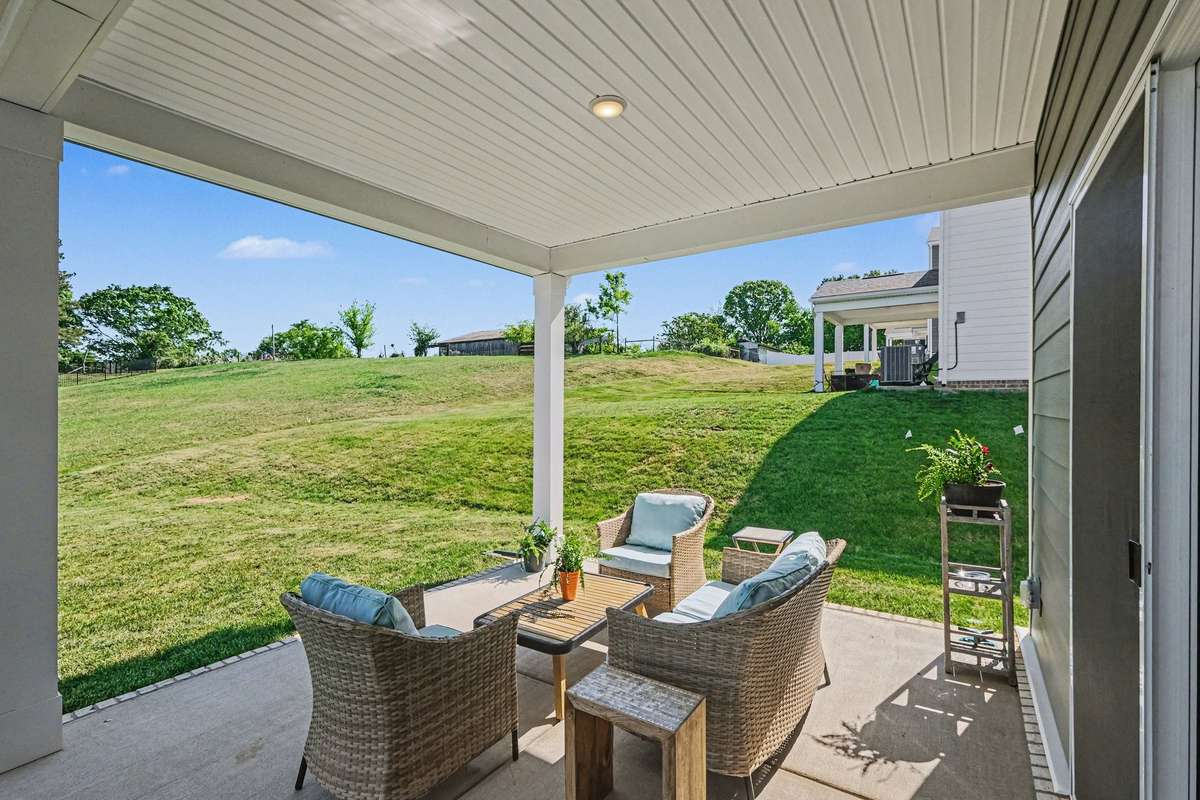 Covered back porch with lots of space and look at the pretty view in the back