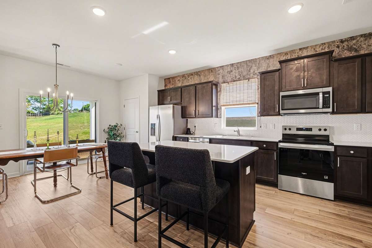 The kitchen has a pantry, beautiful quartz counters and lots of cabinets!