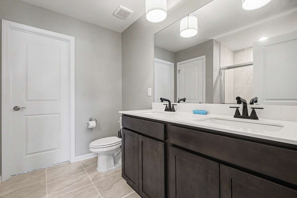 Primary bath, again with new lighting and faucets and fresh paint. All the upstairs bathrooms also have oversized floor tile. The over sized walk in shower is just behind where this picture was taken