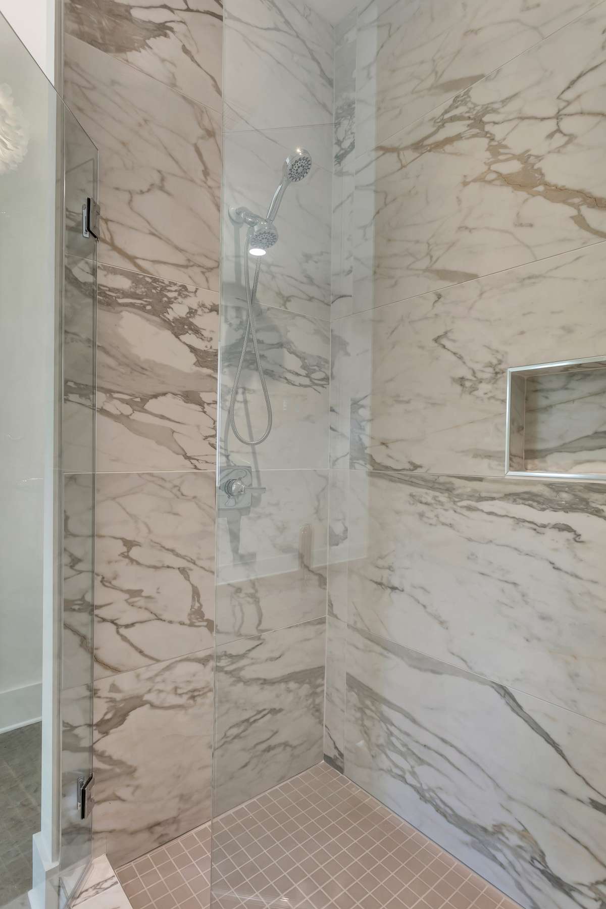 Luscious marble look, these artistic 24 x 48 tile in bathrooms create a spa feel by tiling to the ceiling.