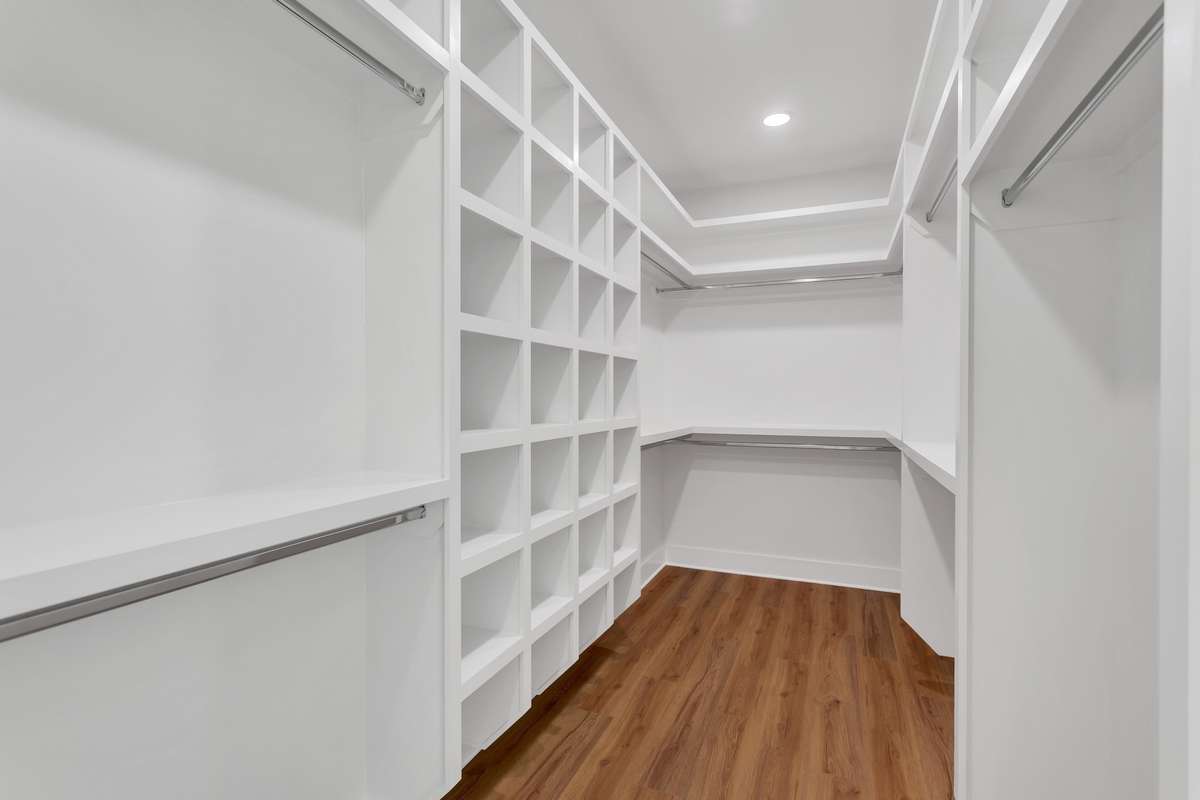 This primary upstairs closet extends the full length of the wall behind your bed, giving you maximum space for your clothes and storage needs.