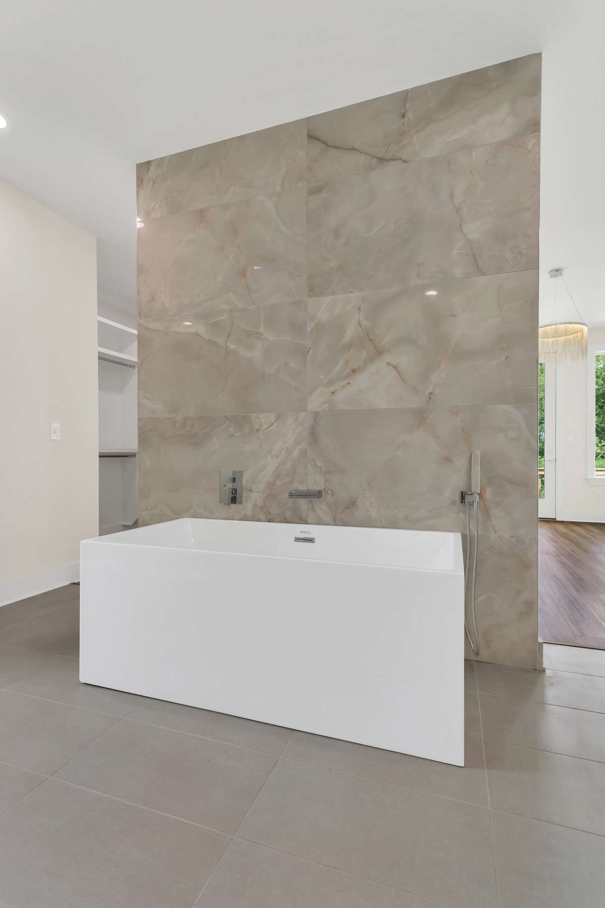 The extra large soaking tub with tile accent matching the shower floor to ceiling, is a great way to unwind after a long days work with a glass of wine.