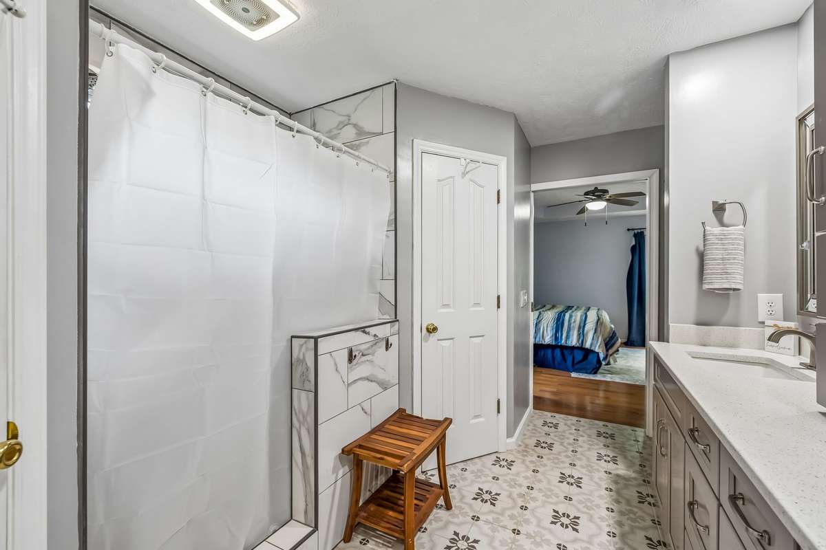 Walk-in shower with plenty of head room, plus the vanity stretches long enough that two people aren't bumping elbows during morning routines.