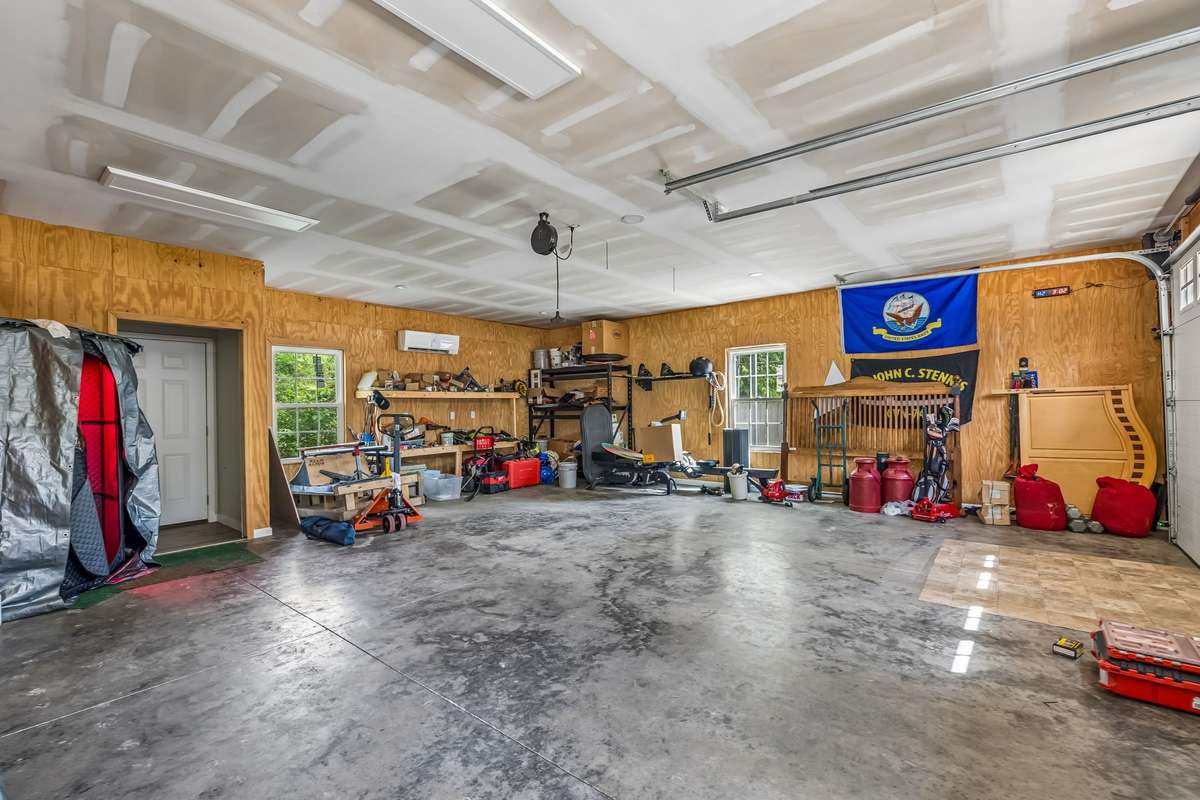 The detached workshop offers a concrete floor and plenty of wall space for organizing tools and equipment, or an ideal set up for a home gym.
