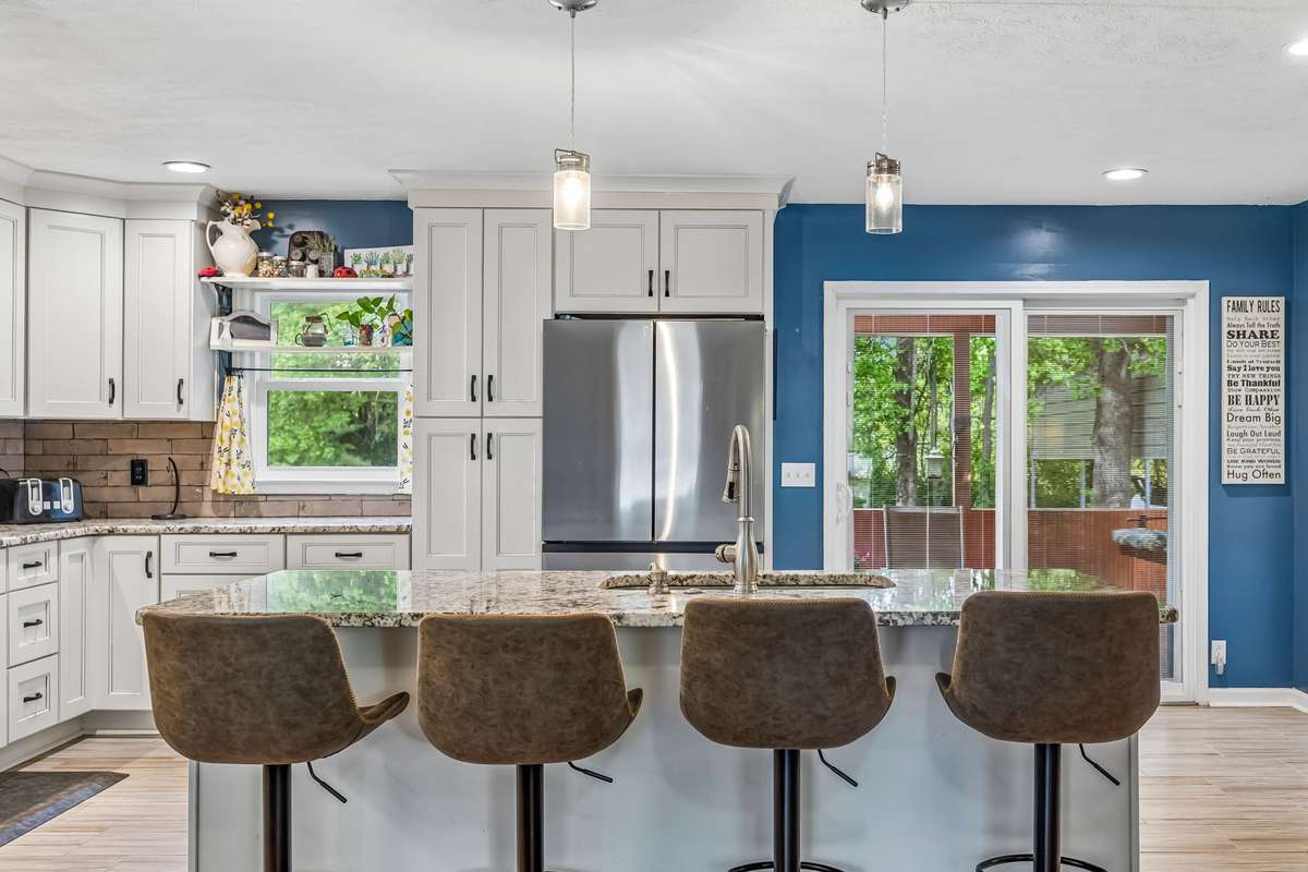 White cabinets with granite counters and a blue accent wall that brings some personality to the space.