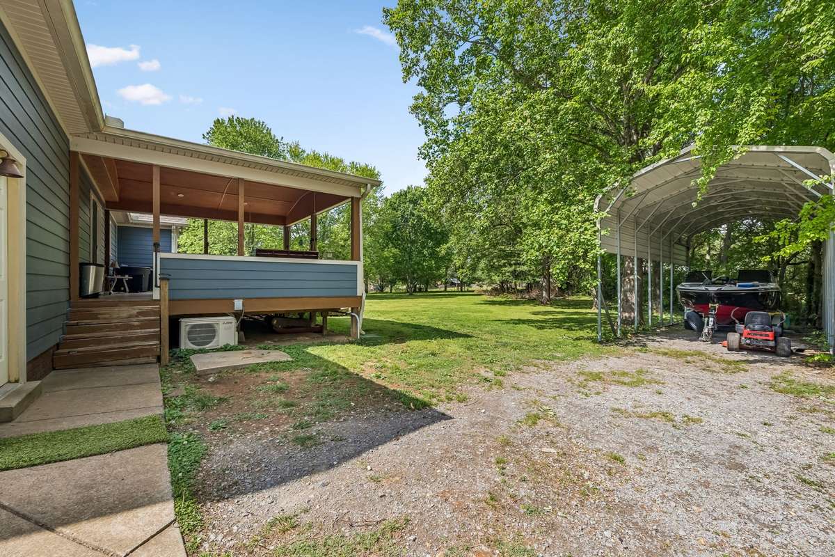 Covered carport provides shelter for vehicles, boat, or RV.