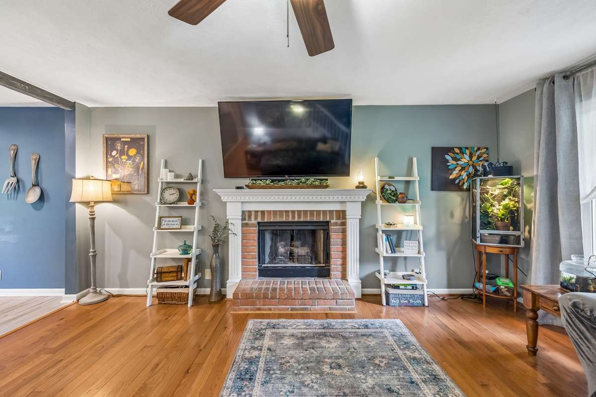 Open living room flows right into the kitchen and dining area, with a brick fireplace.