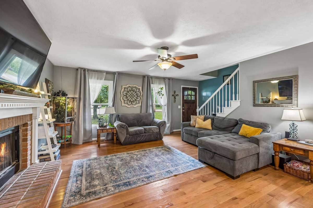 The open floor plan flows from the fireplace area toward the staircase and front entry, creating good sight lines across the main level.