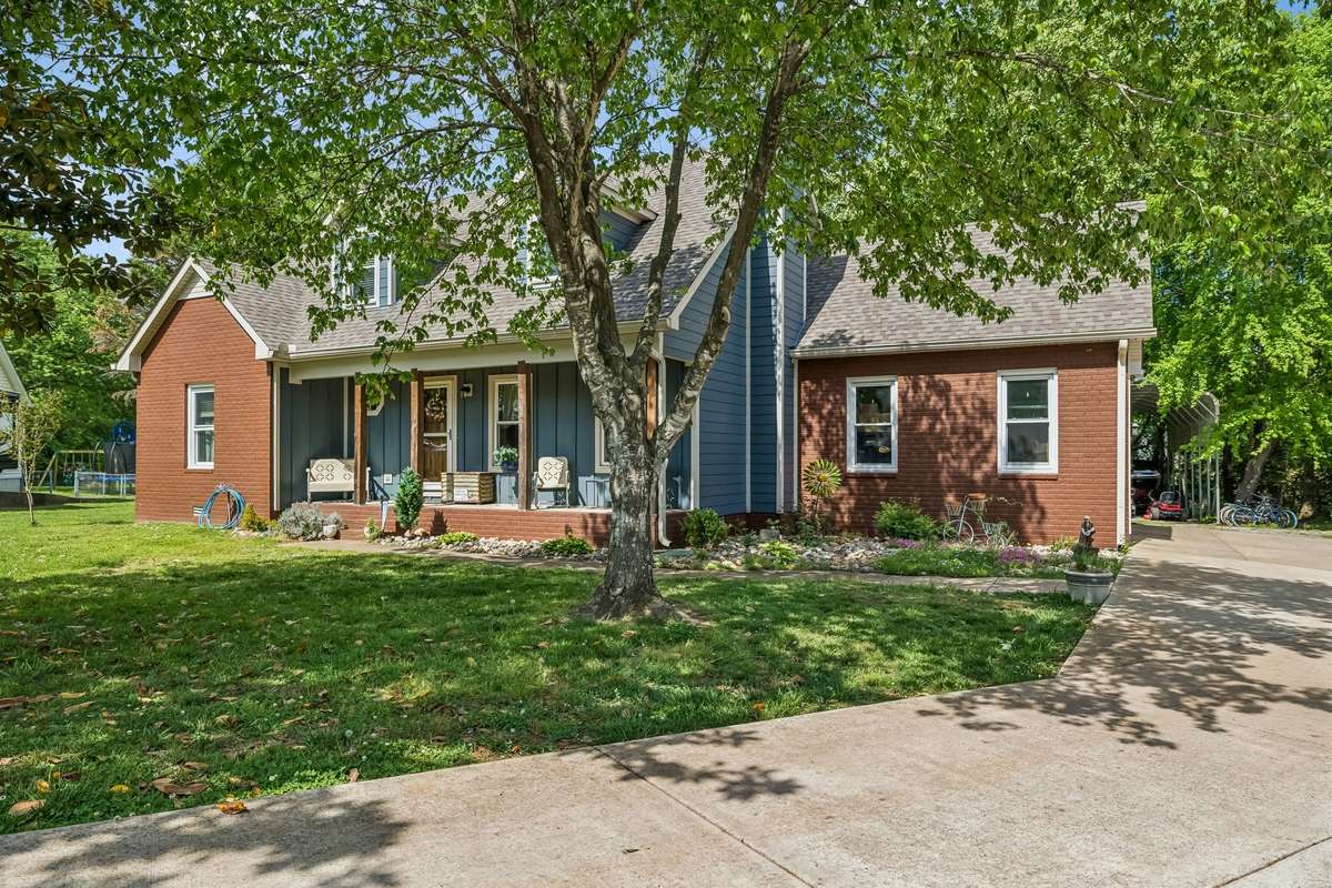 Welcoming covered front porch with enough room for chairs and morning coffee, plus the big shade tree keeps it comfortable even on hot days.