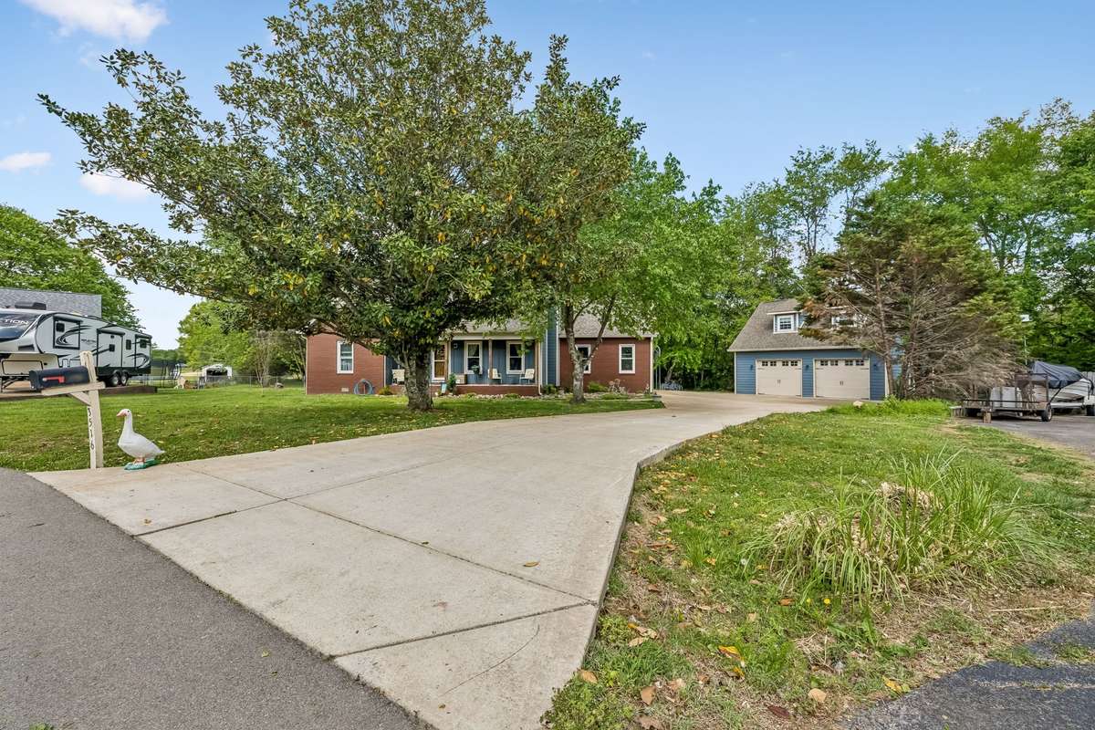 Wide driveway with room for multiple vehicles plus the detached garage with office space above