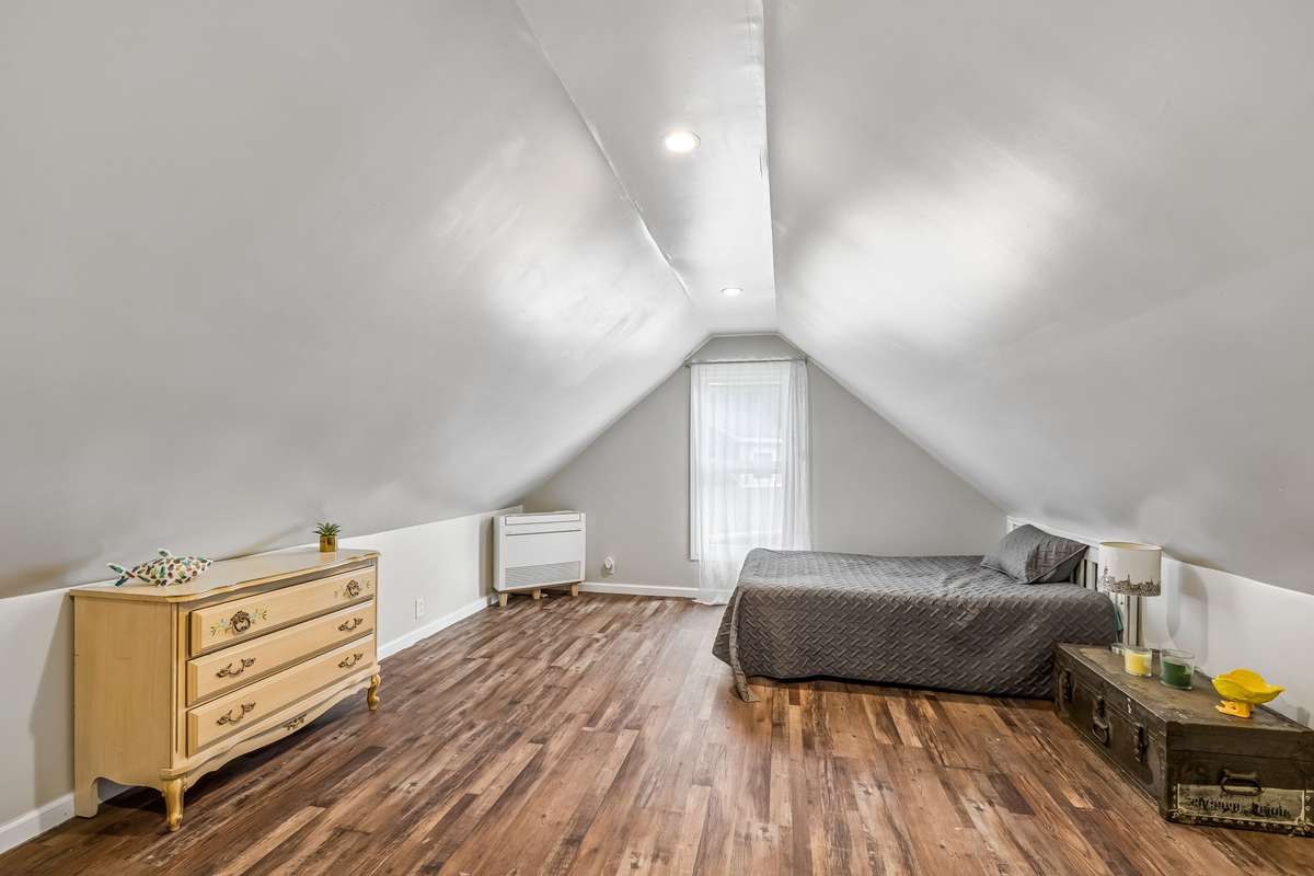 This upstairs bedroom tucks under the roofline with a center window and LVP floors throughout.