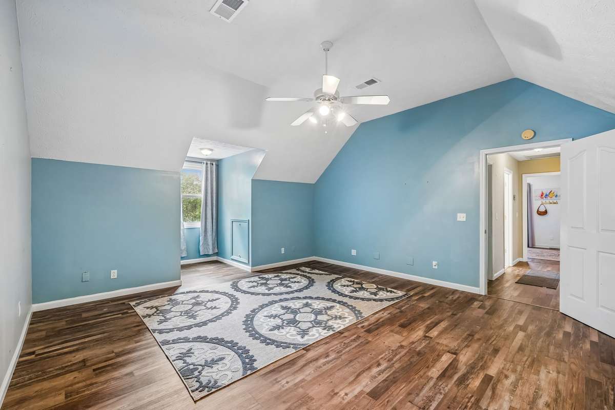 Upstairs bonus room with sloped ceilings and good natural light, could work as a home office, media, or bonus room.