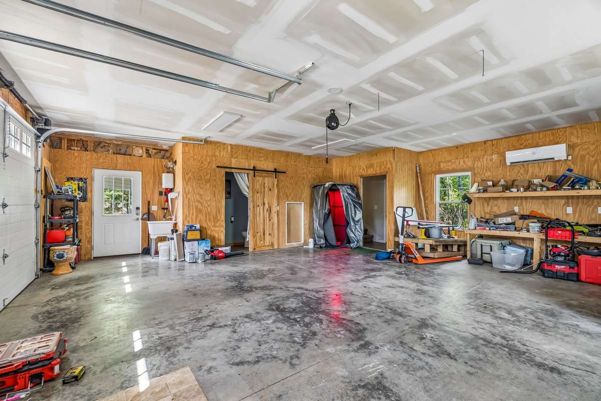 The garage bay doors open to a concrete floor with office space overhead, plus a side entry door for easy access.