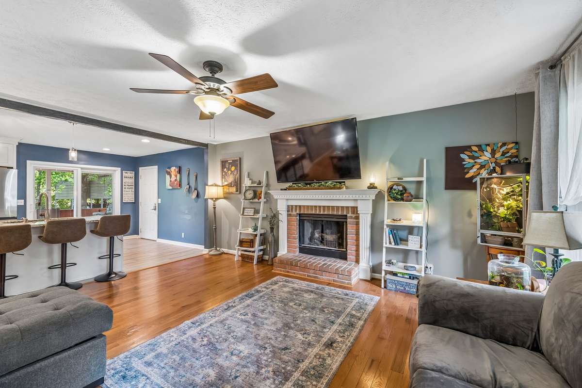 Open living room flows right into the kitchen and dining area, with a brick fireplace.