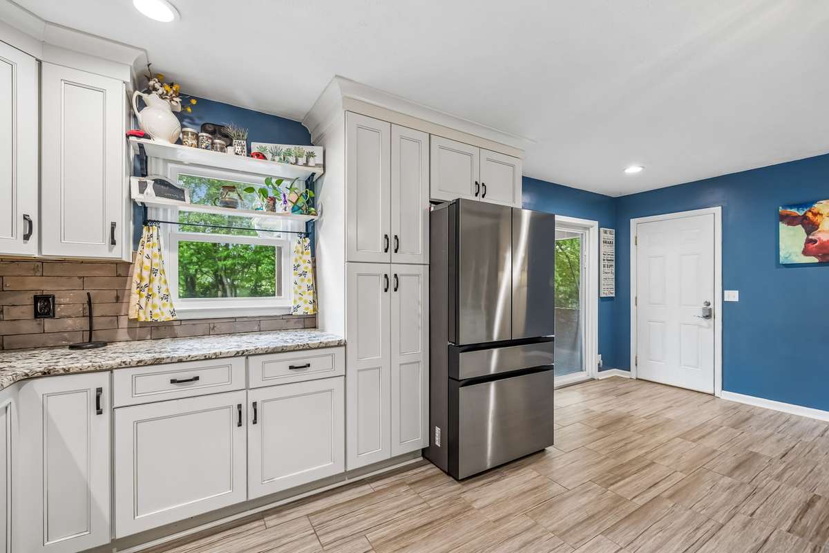 Blue accent wall gives this kitchen some personality while white cabinets keep it from feeling overwhelming.