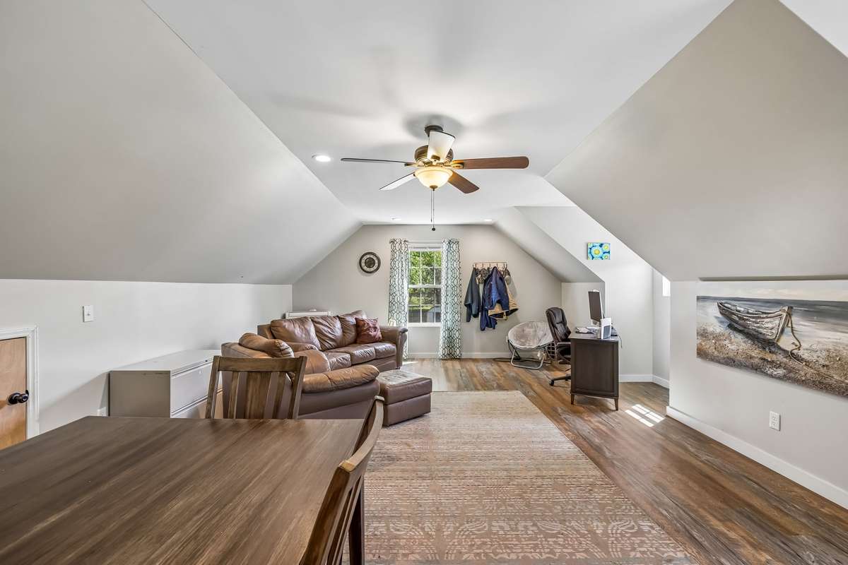This finished space spans the full length with vaulted ceilings and a window that brings in natural light from the front of the house.