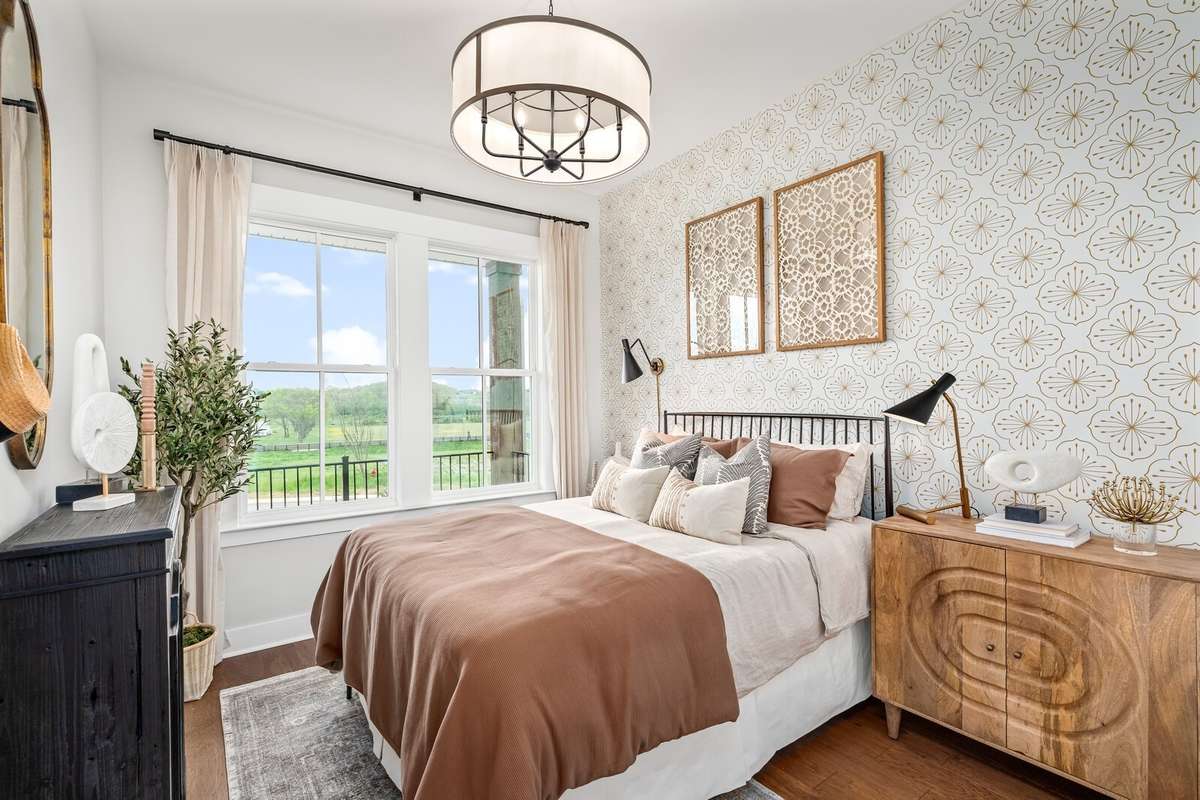 Main level Guest Suite offers a walk in closet and private ensuite bath with shower. All photos with furnishings are from a former Marshall model home and are not the home for sale. They are a likeness.
