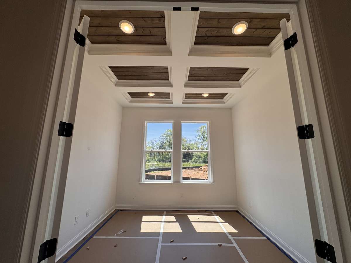 Home Office located on the main level with coffered ceilings which include stained tongue and groove.