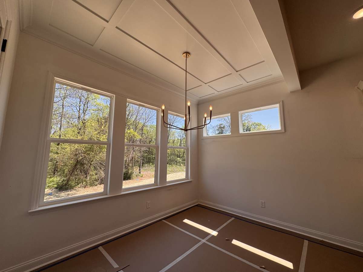 What is not to love about this Dining room which has windows on all three walls, trimmed ceiling and a view of the trees.