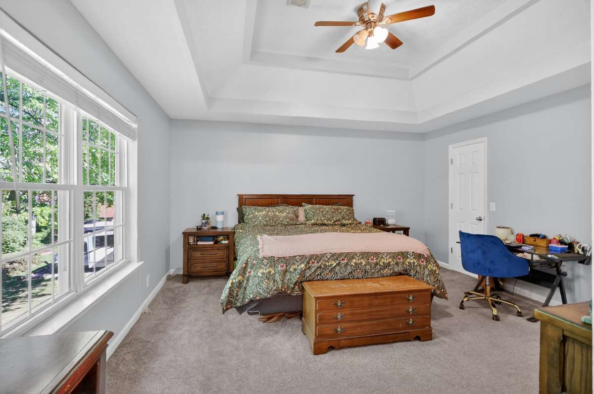 The primary bedroom is spacious with a double trey ceiling and soft carpet
