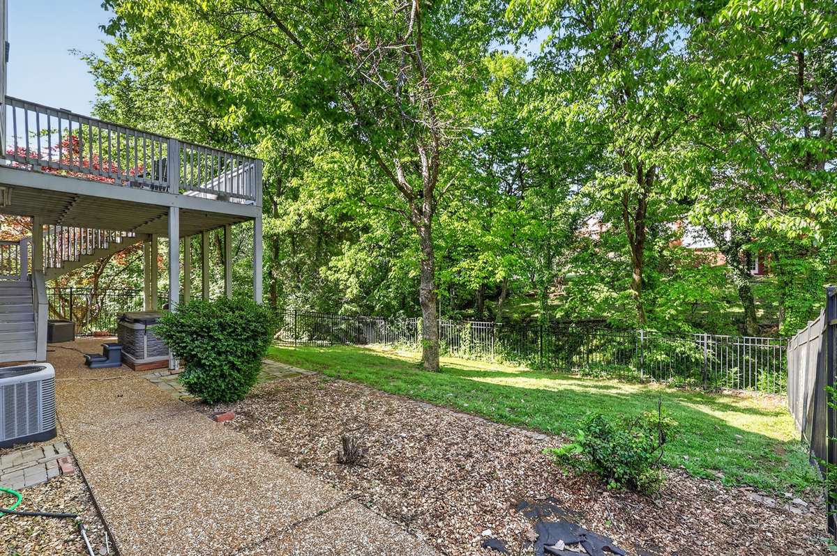 Beautiful back yard with a full metal fence backs to a treeline and creek bed
