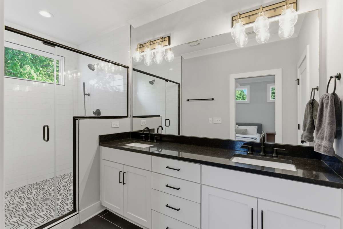 The wide mirror frames a quartz vanity with plenty of cabinet space.