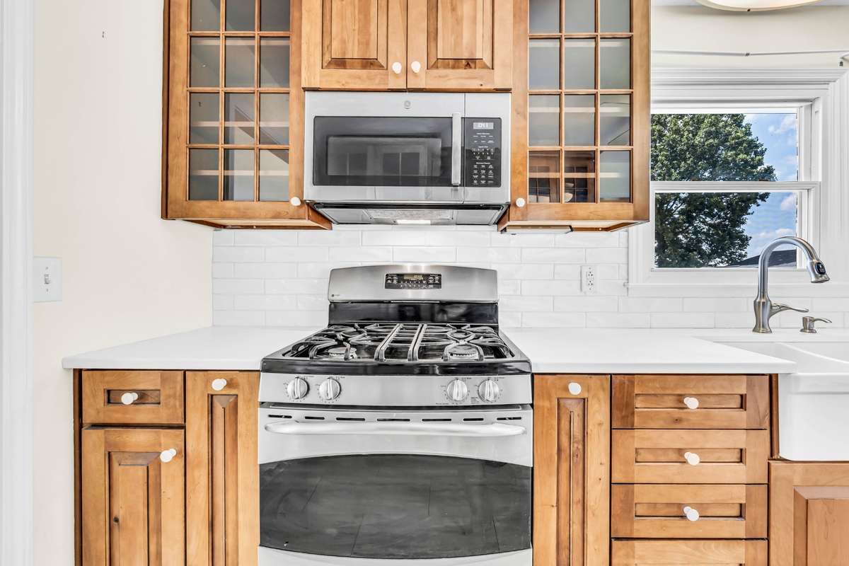 Custom-built cabinets with soft-close drawers and pull-out shelves, quartz countertops, and a gas stove.