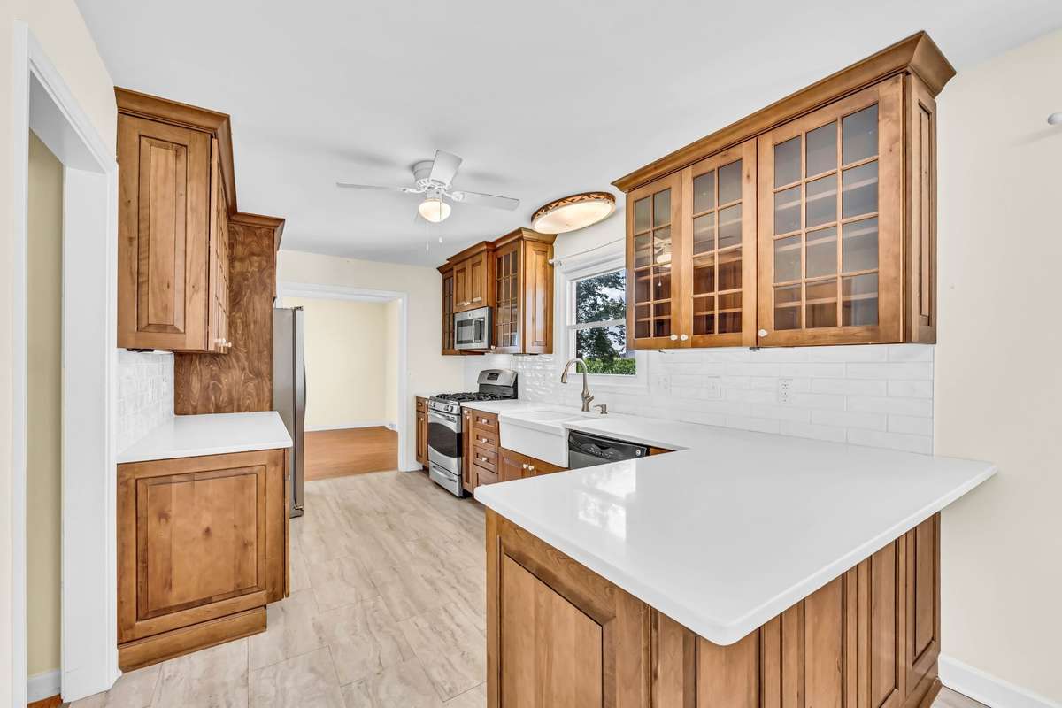 Custom-built cabinets with soft-close drawers and pull-out shelves, quartz countertops, and a gas stove.