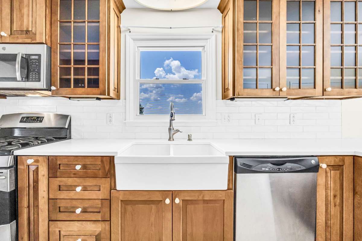 Custom-built cabinets with soft-close drawers and pull-out shelves, quartz countertops, and a gas stove.