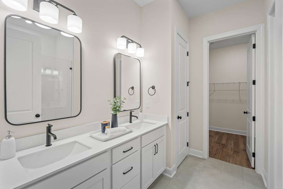 Two square sinks, quartz countertops, designer mirrors and lighting