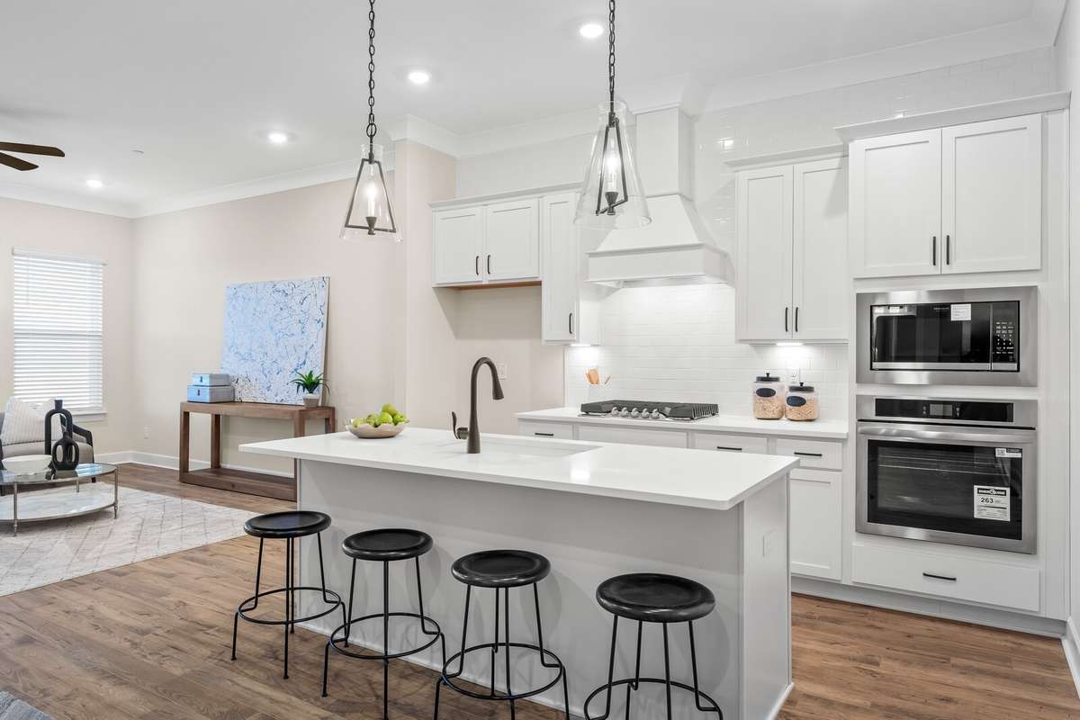 Chef's kitchen with large island, gas cooktop and ovens built into wall cabinet