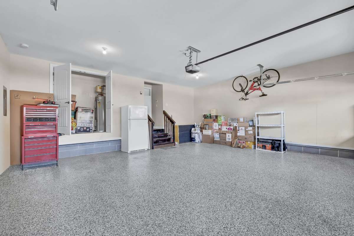 Spacious garage with custom flooring easily accommodates two SUVs.