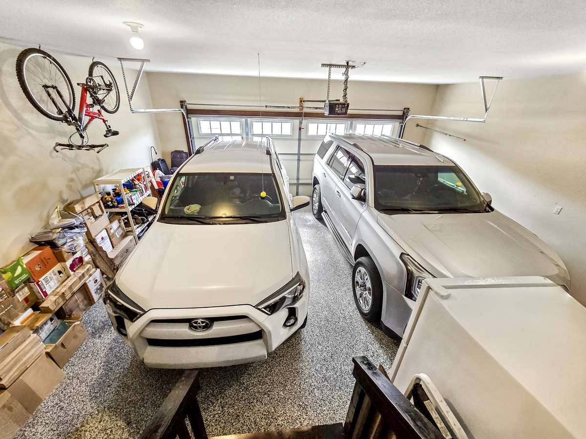 Spacious garage with custom flooring easily accommodates two SUVs.