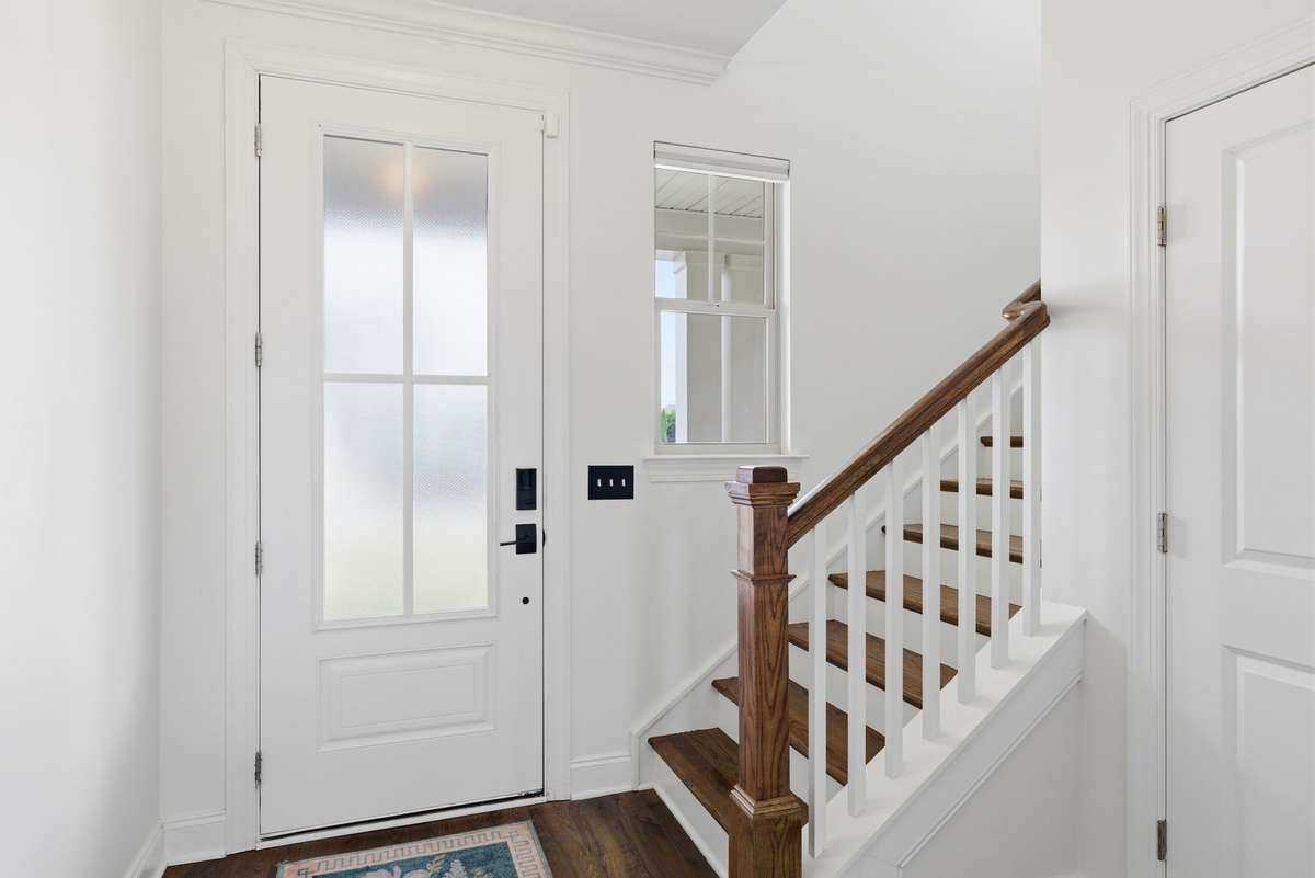 Entry with staircase view and front door with opaque glass for added privacy, while still bringing in tons of natural light
