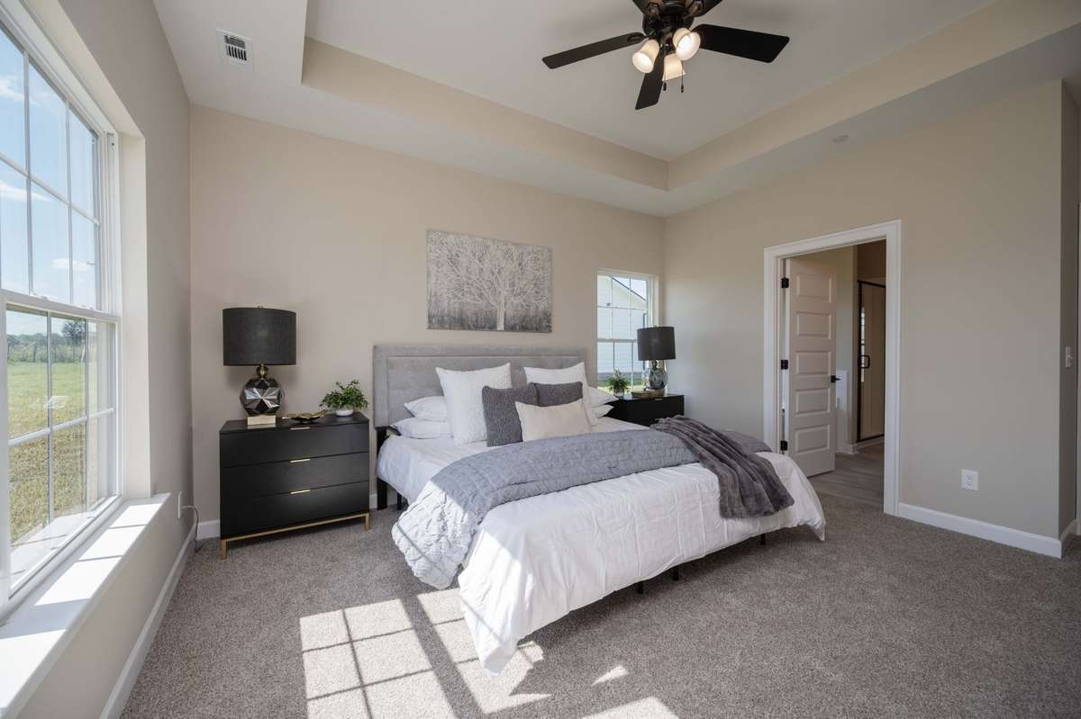 Photo from previous build of the same plan. Main level primary with trey ceiling, remote controlled ceiling fan and large ensuite bathroom