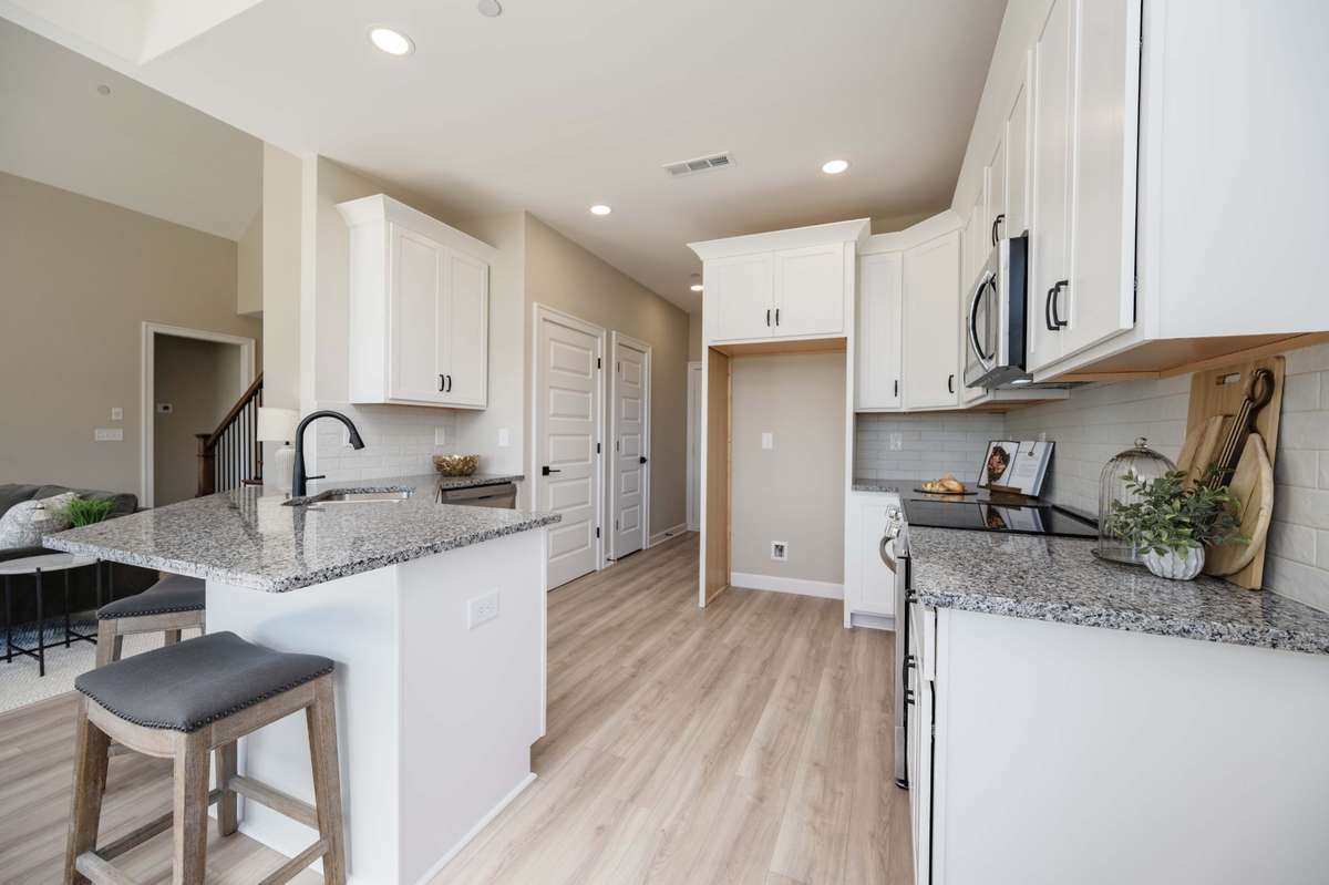 Photo from previous build of the same plan. Select from quartz or granite counter tops. Tiled backsplash and extra tall, fully trimmed uppers. All cabinets come with soft close hardware